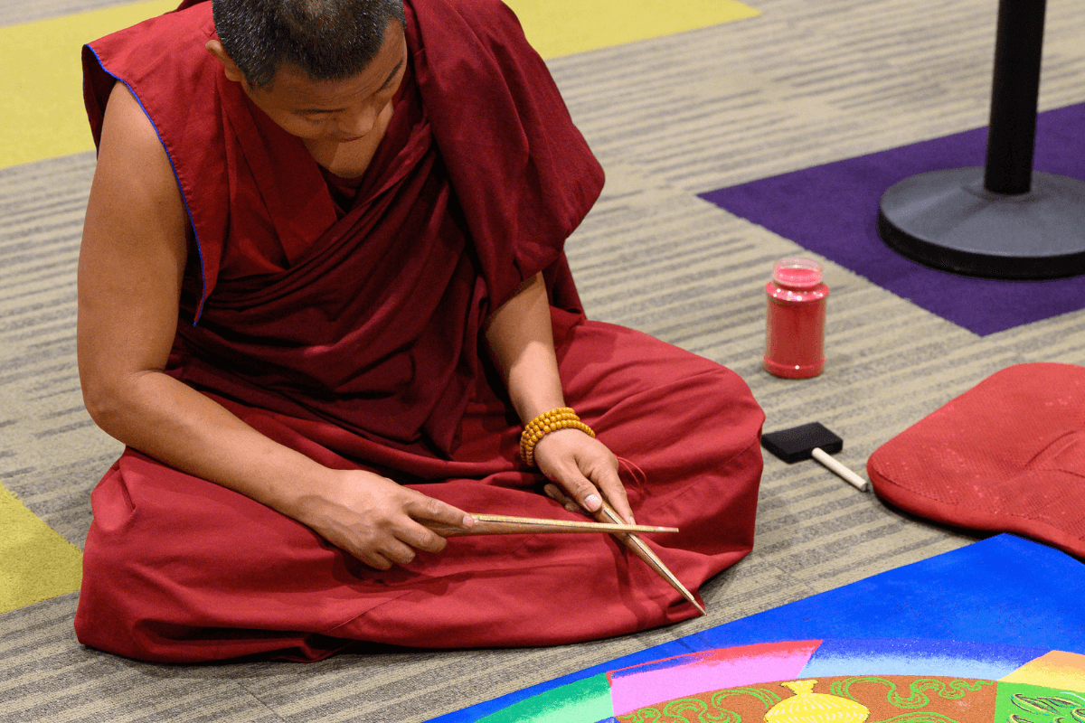 A Tashi Kyil monk uses tools for a cultural presentation during convocation.